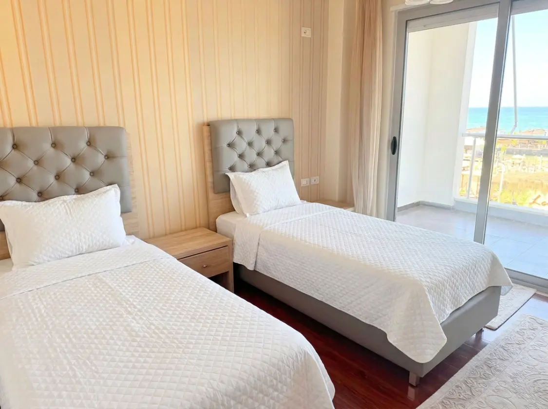 firefly-gemini-flash-enhance-brightness-make-the-beds-with-w Beachfront Two-Bedroom Apartment for Sale in Durrës